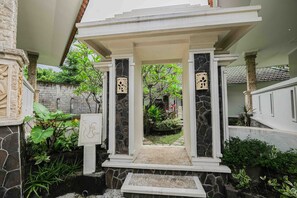 A covered entrance with stone columns and a sign that reads "Yes Spa." - Poinciana Resort Bali (Tejakula)