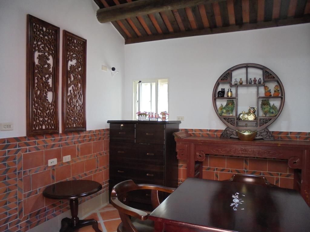 Un comedor con mesa de madera, sillas, un armario y un espejo decorativo.