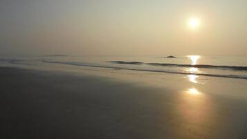 Una playa con el sol reflejado en el agua.