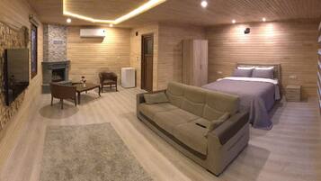 A cozy room with a fireplace, a sofa, a bed, and a wardrobe.