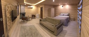 A cozy room with a fireplace, a sofa, a bed, and a wardrobe. - Pinar Kir Evi (Arhavi)