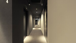 A long, narrow hallway with a carpeted floor and walls on both sides. - FUGASTAY Shijo Omiya (Kyoto)
