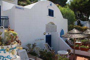 A white building with a blue door and window shutters, labeled "Dependance No. 2". - Hotel Elisa (Peschici)