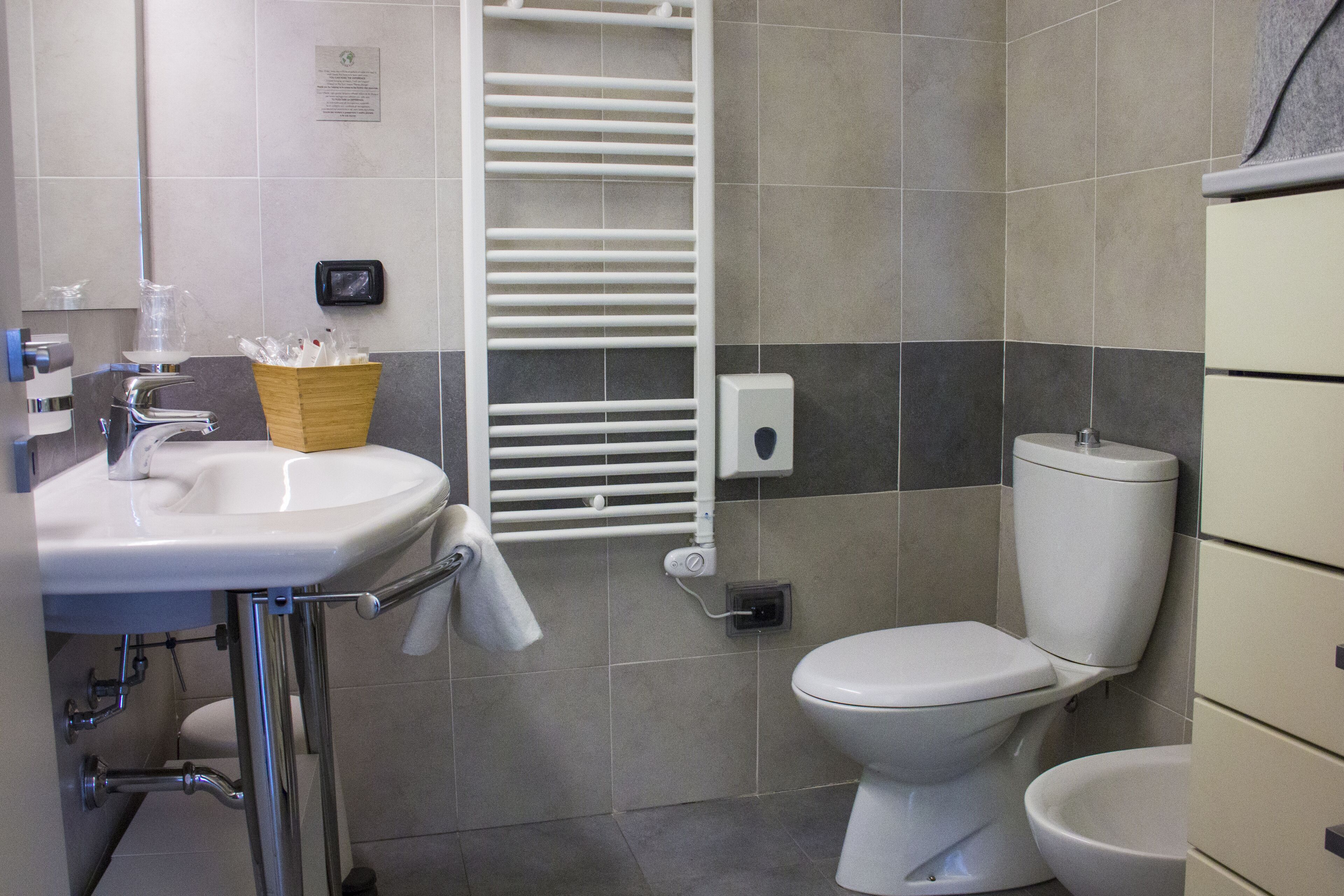 Un baño moderno con lavamanos, inodoro y toallero.
