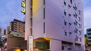 A modern hotel with a prominent 'HOTEL' sign, multiple floors, and a flat facade. - Hotel Oak Shizuoka (Shizuoka)