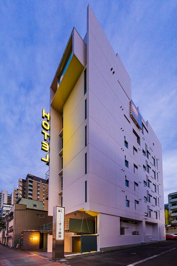 A modern hotel with a prominent 'HOTEL' sign, multiple floors, and a flat facade. - Hotel Oak Shizuoka (Shizuoka)