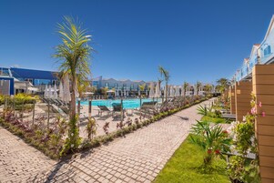 Una piscina al aire libre, sillones reclinables de piscina