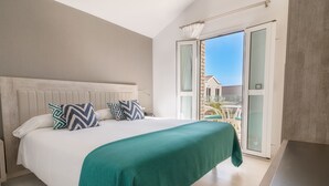 A bedroom with a bed, a green bedspread, and a view of the outside through a sliding glass door. - Hotel LIVVO Los Calderones - Adults Recommended (San Bartolomé de Tirajana)