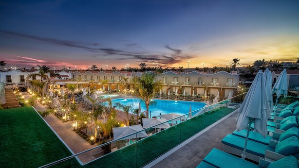 A resort with a large swimming pool, multiple lounge areas, and a view of the sunset. - Hotel LIVVO Los Calderones - Adults Recommended (San Bartolomé de Tirajana)