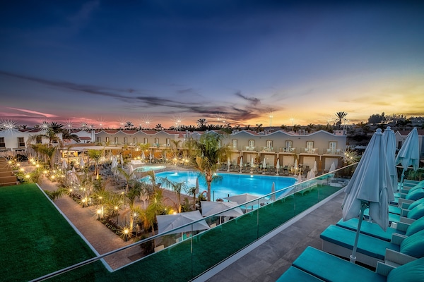 Una piscina al aire libre, tumbonas