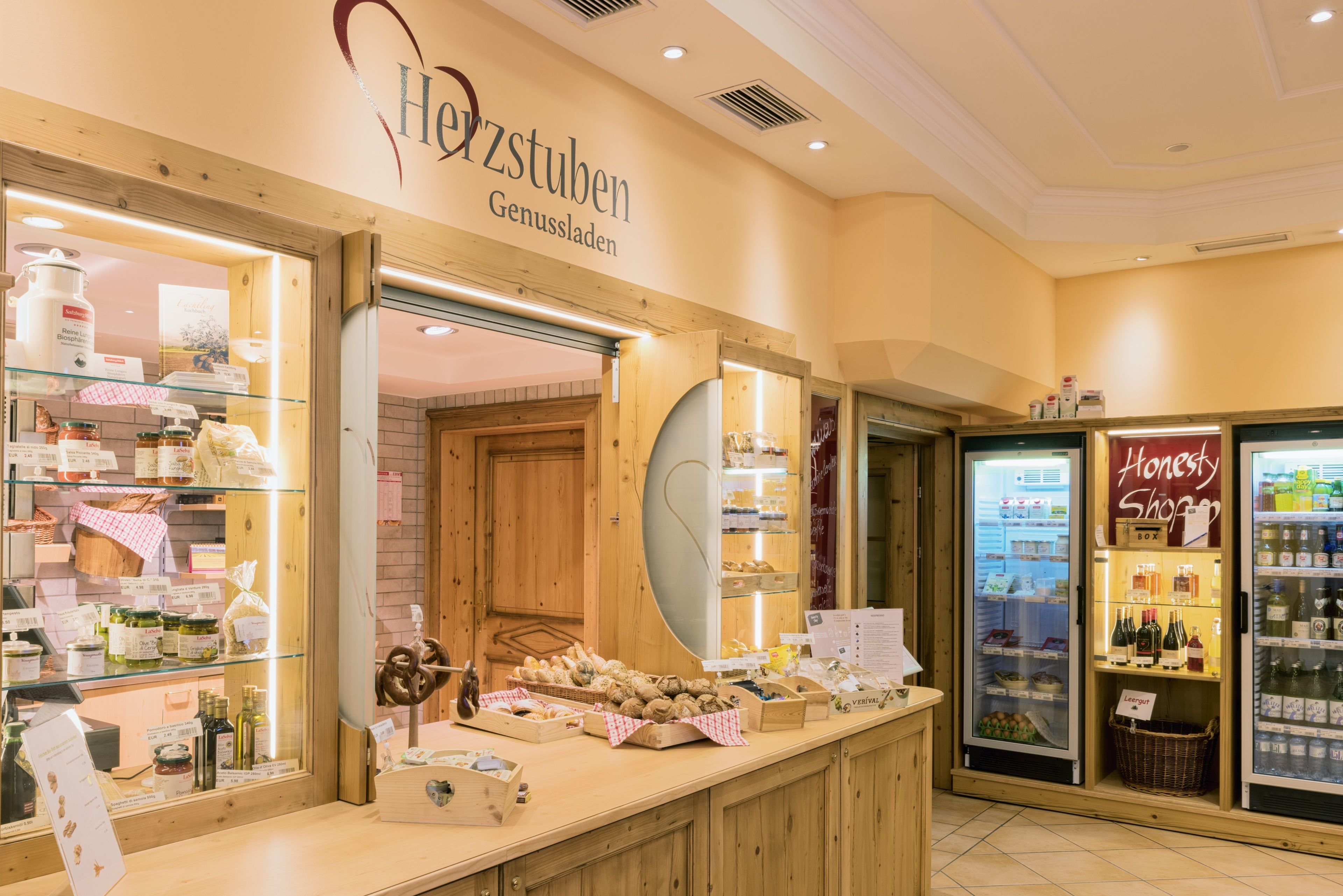 A bakery with wooden counters and a display case filled with pastries and baked goods.