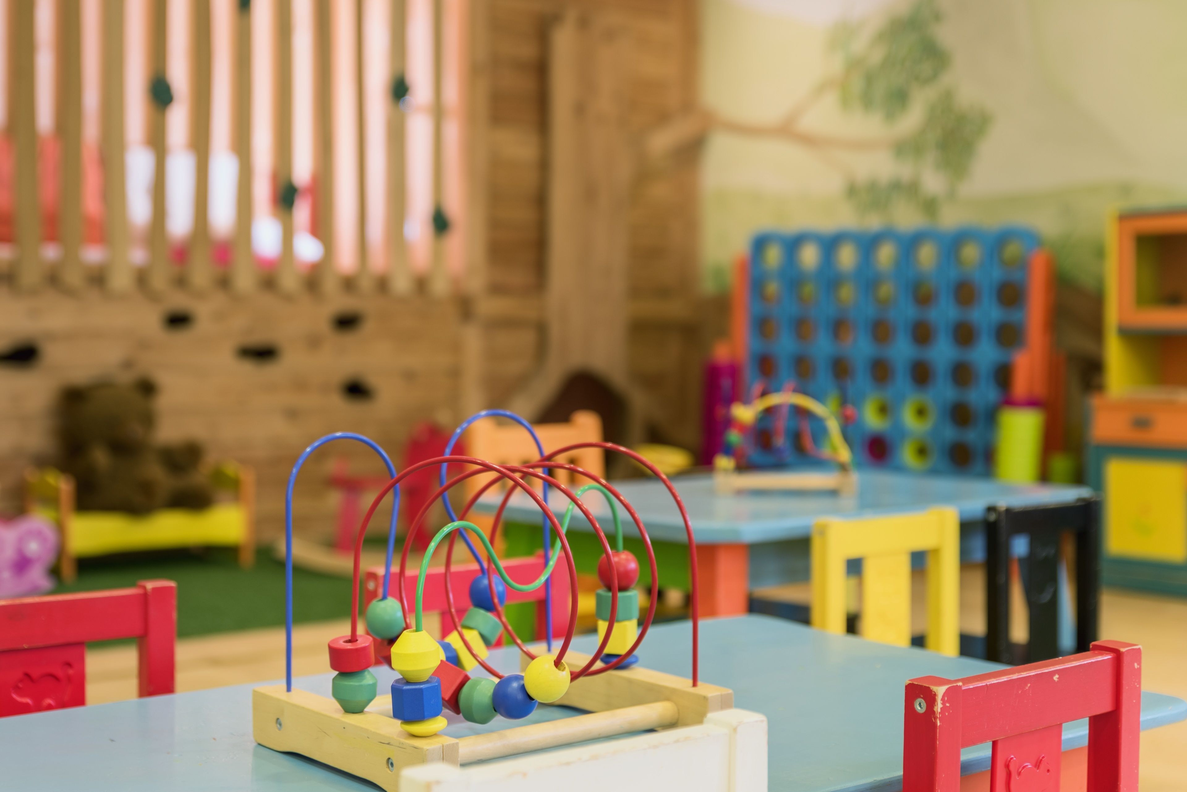 Un área de juegos infantiles con juguetes y mobiliario de colores.