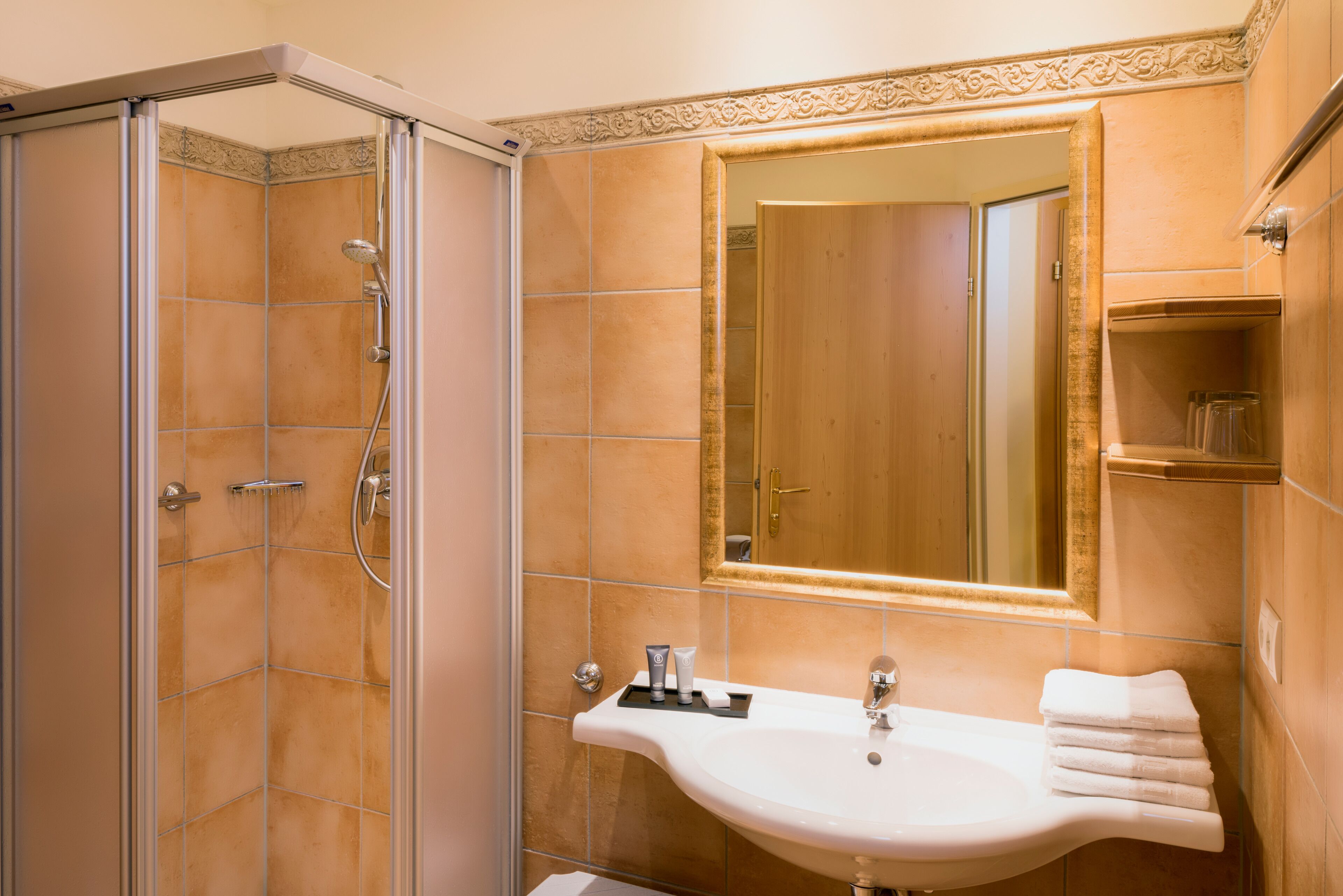 Un baño con ducha, lavamanos y espejo.
