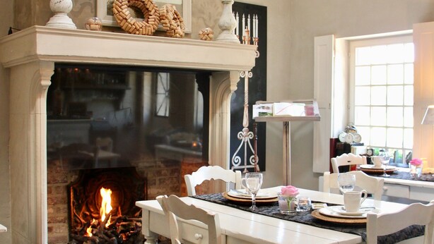 Una habitación acogedora con chimenea, una mesa de comedor con sillas y una ventana con vistas.