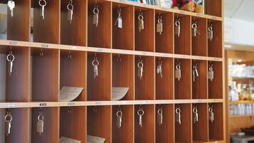 Ein Schlüsselschrank mit nummerierten Fächern, in jedem Fach Schlüssel und ein Papier.