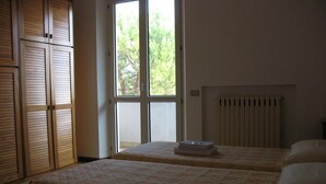 A bedroom with two beds, a window, and a radiator. - Bed & Breakfast Bompadre (Civitanova Marche)
