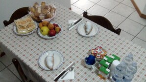 A dining table with plates of food, including sandwiches and fruits, and a few bottles of water. - Bed & Breakfast Bompadre (Civitanova Marche)