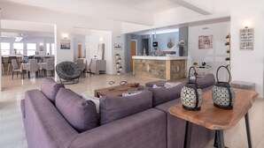 Una sala de estar moderna con un sofá morado, una mesa de centro de madera y dos faroles decorativos.
