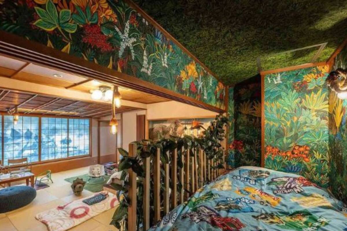 A room with a bed, a window, and a mural.
