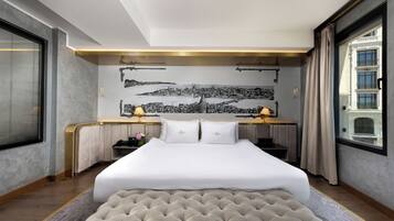 Ein Hotelzimmer mit einem großen Bett, einem Schreibtisch und einem Wandgemälde mit Stadtansicht.