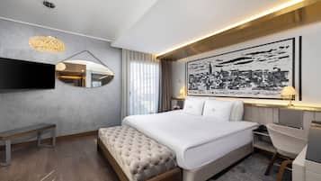 A modern hotel room with a large bed, a flat-screen TV, a bedside table, a chair, and a large cityscape artwork on the wall.
