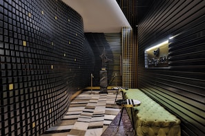 A modern hotel lobby with a geometric patterned floor, a green upholstered bench, and a wall with a grid-like design. - The Wings Hotels Karakoy (Istanbul)