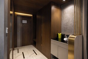 A modern bathroom with wooden cabinetry, a black countertop, and a mirror with vertical gold accents. - The Wings Hotels Karakoy (Istanbul)