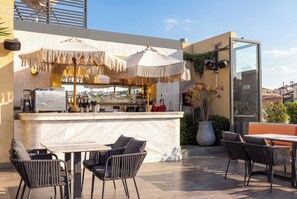 A rooftop bar with a marble counter, outdoor seating, and a view of the cityscape. - The Wings Hotels Karakoy (Istanbul)