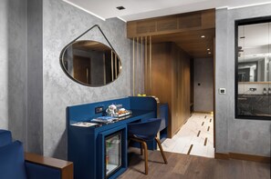 A modern hotel room with a desk, chairs, a round mirror, and a view of the city through a window. - The Wings Hotels Karakoy (Istanbul)