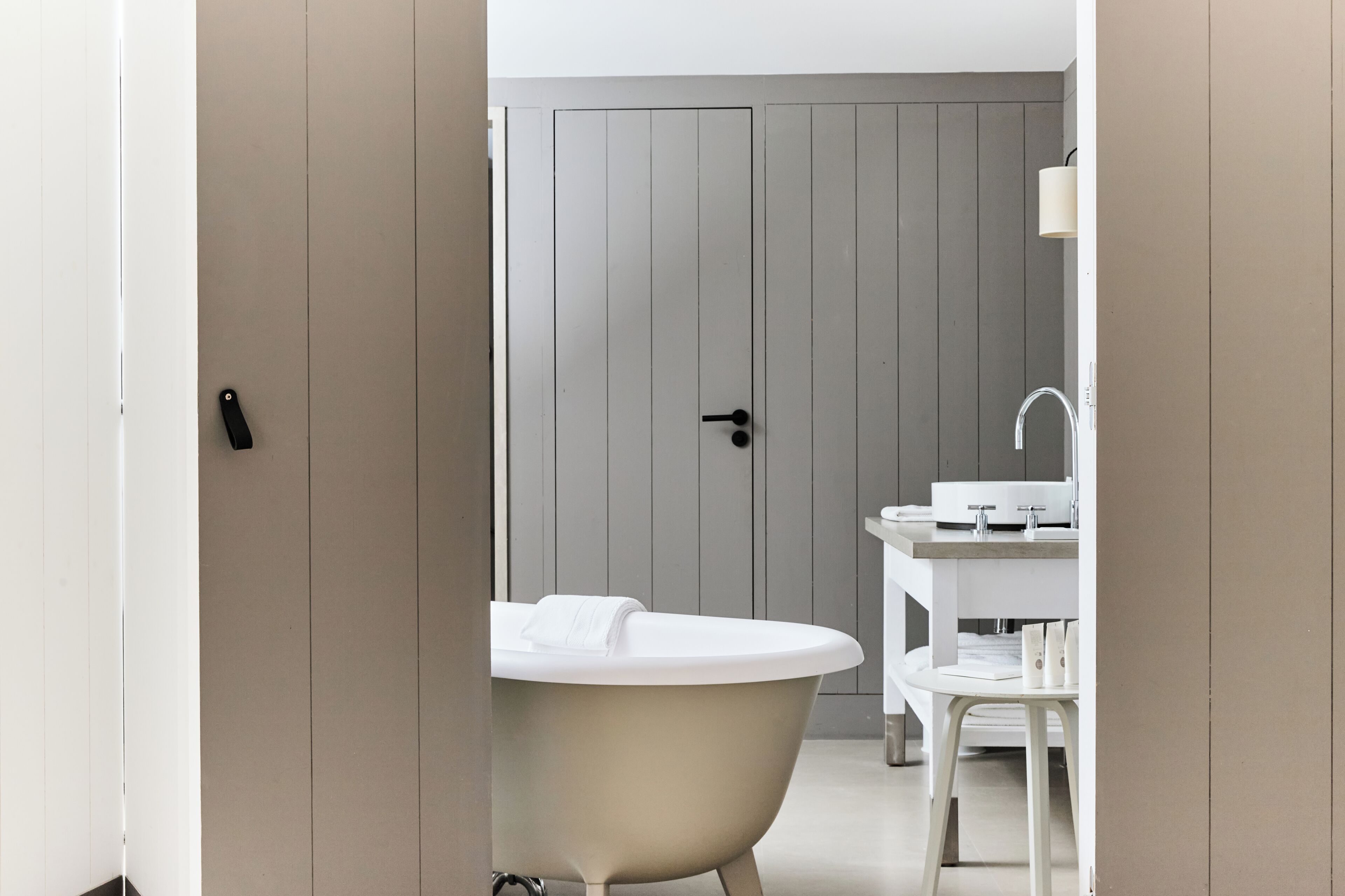 A bathroom with a freestanding bathtub, a white sink, and a mirror.