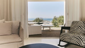 A balcony with a sofa, a chair, and a small table. - Hôtel Plage Palace & Spa (Palavas-les-Flots)