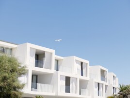 Un edificio moderno de varios pisos con balcones y ventanas amplias.