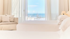 A hotel room with a bed, a sofa, and a view of the sea. - Hôtel Plage Palace & Spa (Palavas-les-Flots)