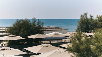 A beachside resort with multiple umbrellas and a pool.