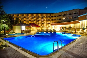 Een buitenzwembad, parasols voor strand/zwembad