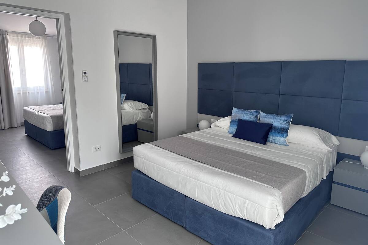 Une chambre moderne avec un grand lit, une table de chevet et une armoire.