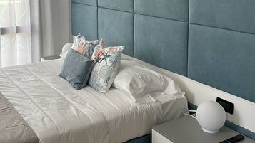 Een moderne slaapkamer met een bed, nachtkastjes en een nachttafeltje.