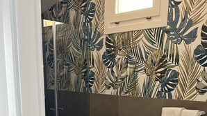 Une salle de bain équipée d’une douche, de toilettes, d’un lavabo et d’un porte-serviettes.