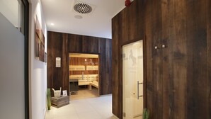 Een receptiegedeelte met een houten wand, een receptiebalie en een sauna zichtbaar door de deur.