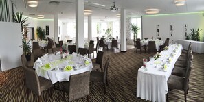 A spacious dining area with multiple round tables set for service, surrounded by chairs. - Hotel Restaurant Sachsenross (Norten-Hardenberg)