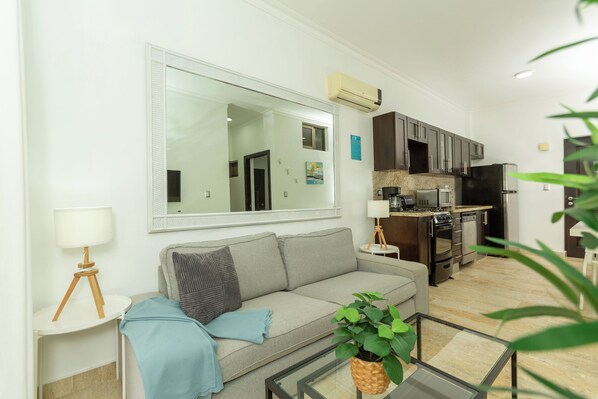 A modern living room with a sofa, a coffee table, and a large mirror. - Grand Laguna Beach Properties by Calisto Stays (Sosúa)