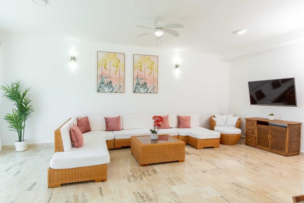 A modern living room with a sectional sofa, a coffee table, a TV, and a cabinet.