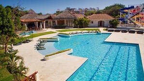 Ein großer Swimmingpool mit Liegestühlen und einer Wasserrutsche.