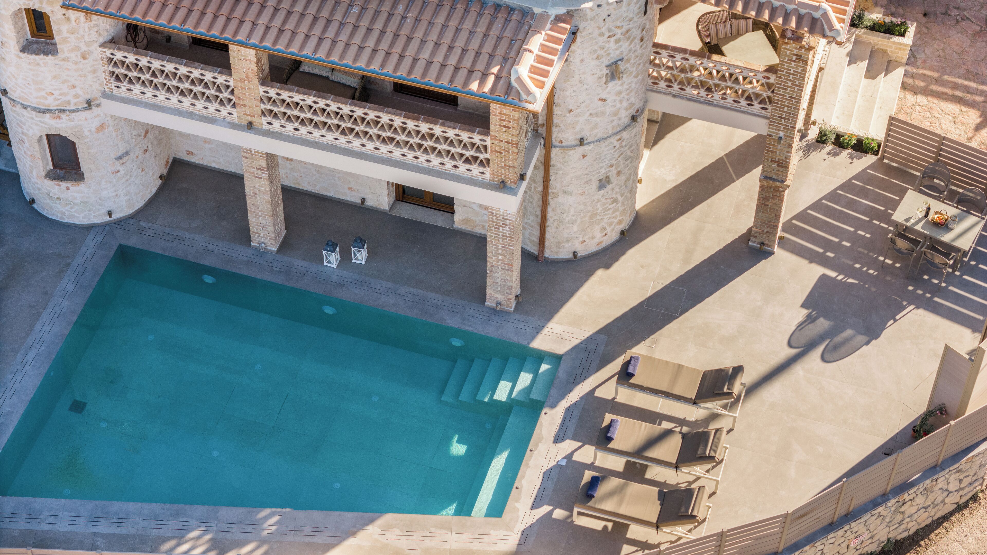Una grande piscina all'aperto con un edificio in pietra sullo sfondo.