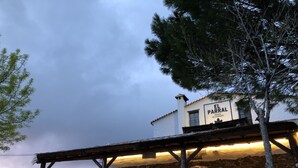 Un edifici de pedra amb un rètol que diu “El Parral Posada Restaurante” a la posta de sol.