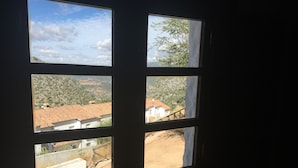 Una finestra amb diversos vidres, cadascun amb vista a un paisatge rural ple d'edificis i vegetació.