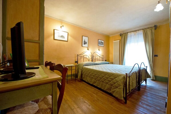 Ein Schlafzimmer mit einem Bett, einem Schreibtisch mit Computer und einem Stuhl.