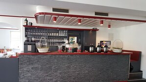 A bar area with a stone counter, wine bottles, and glassware. - Ratskeller Nörten (Norten-Hardenberg)