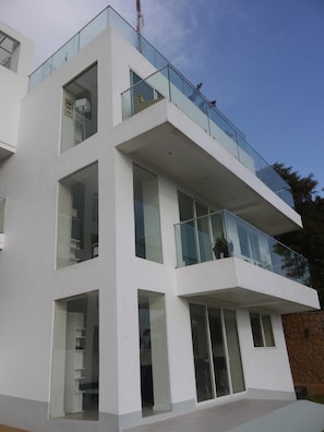 A modern multi-story building with large windows and balconies.