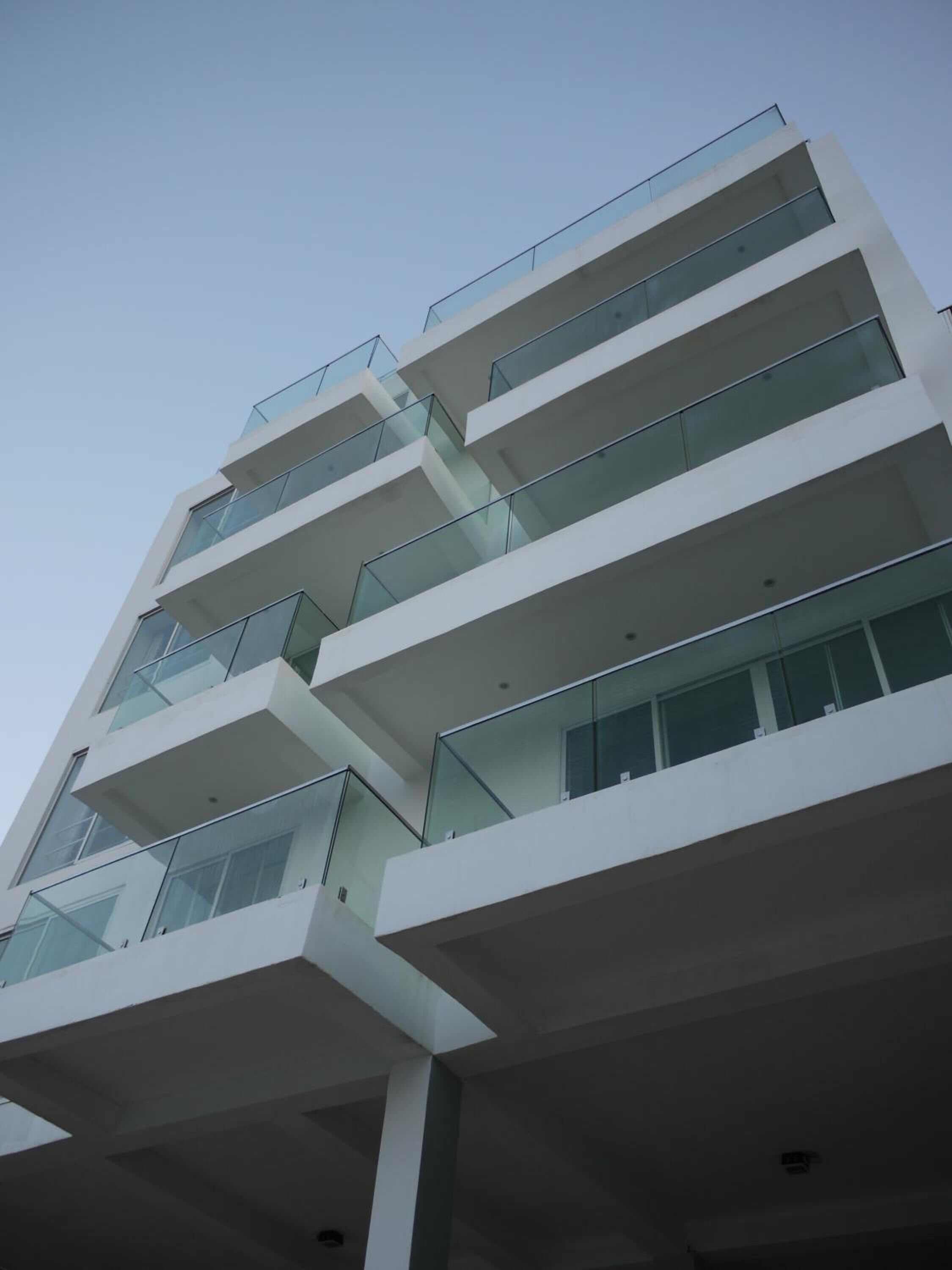 Un immeuble moderne à plusieurs étages, doté de balcons et de grandes fenêtres.